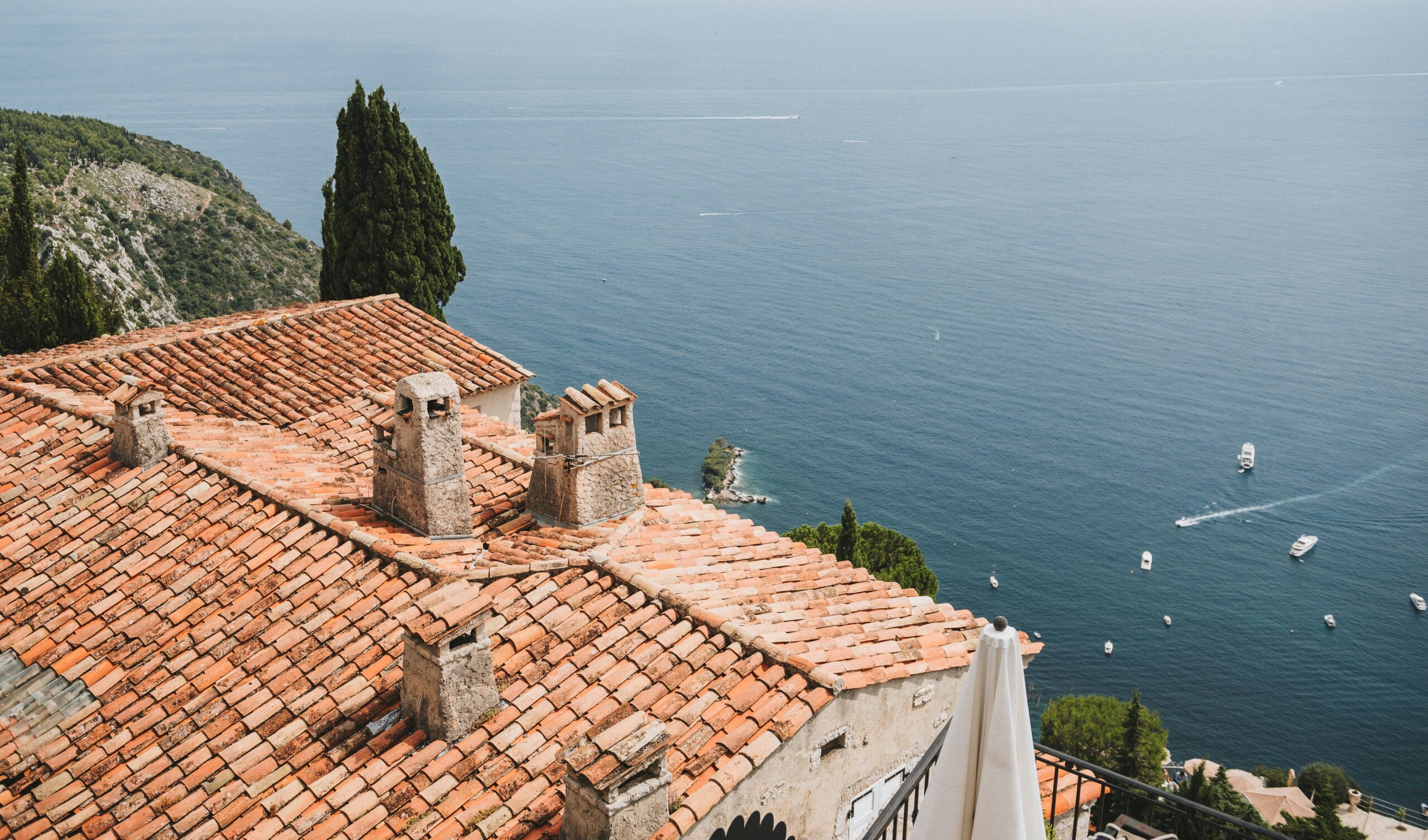 Terracotta rooftops of Èze descending toward the Mediterranean coast