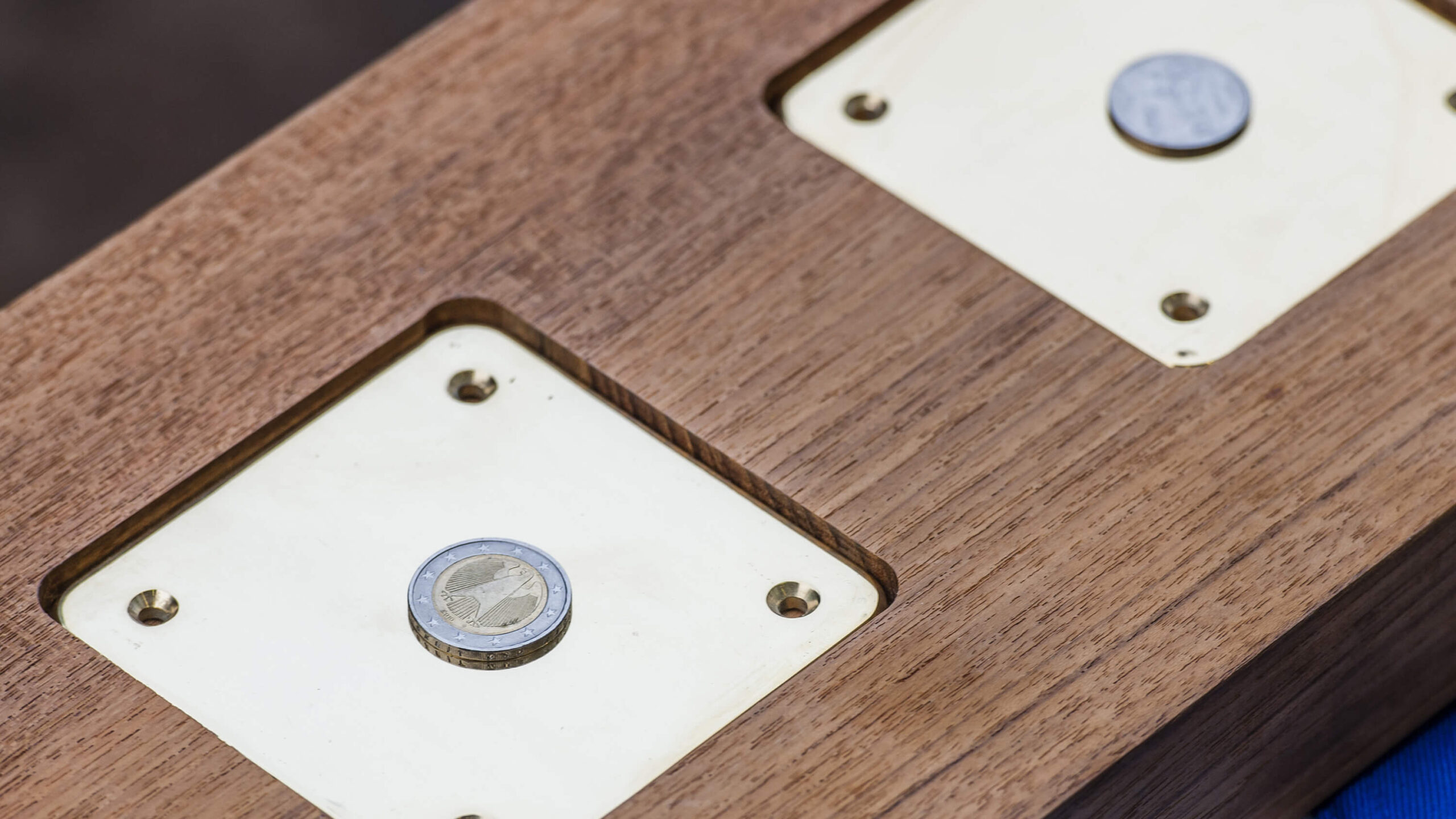 Precision inlays and timber detailing shown with coins as scale references