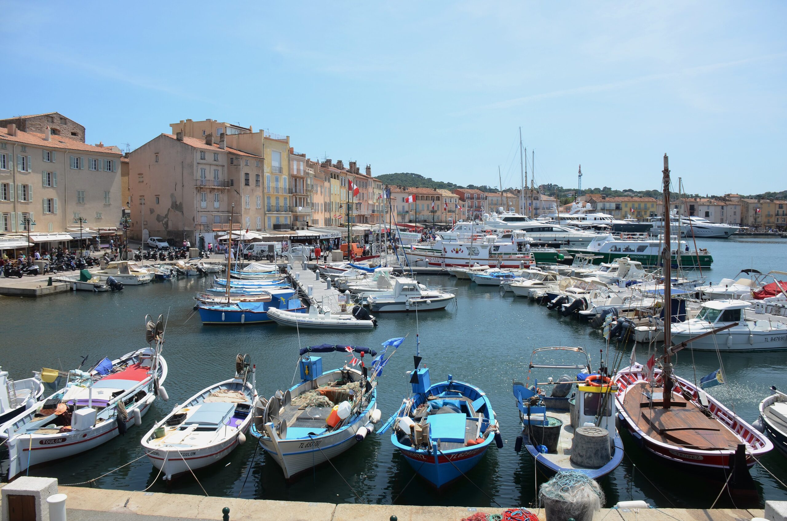 Panoramic view of yachts and ochre buildings around the old harbour of Saint-Tropez