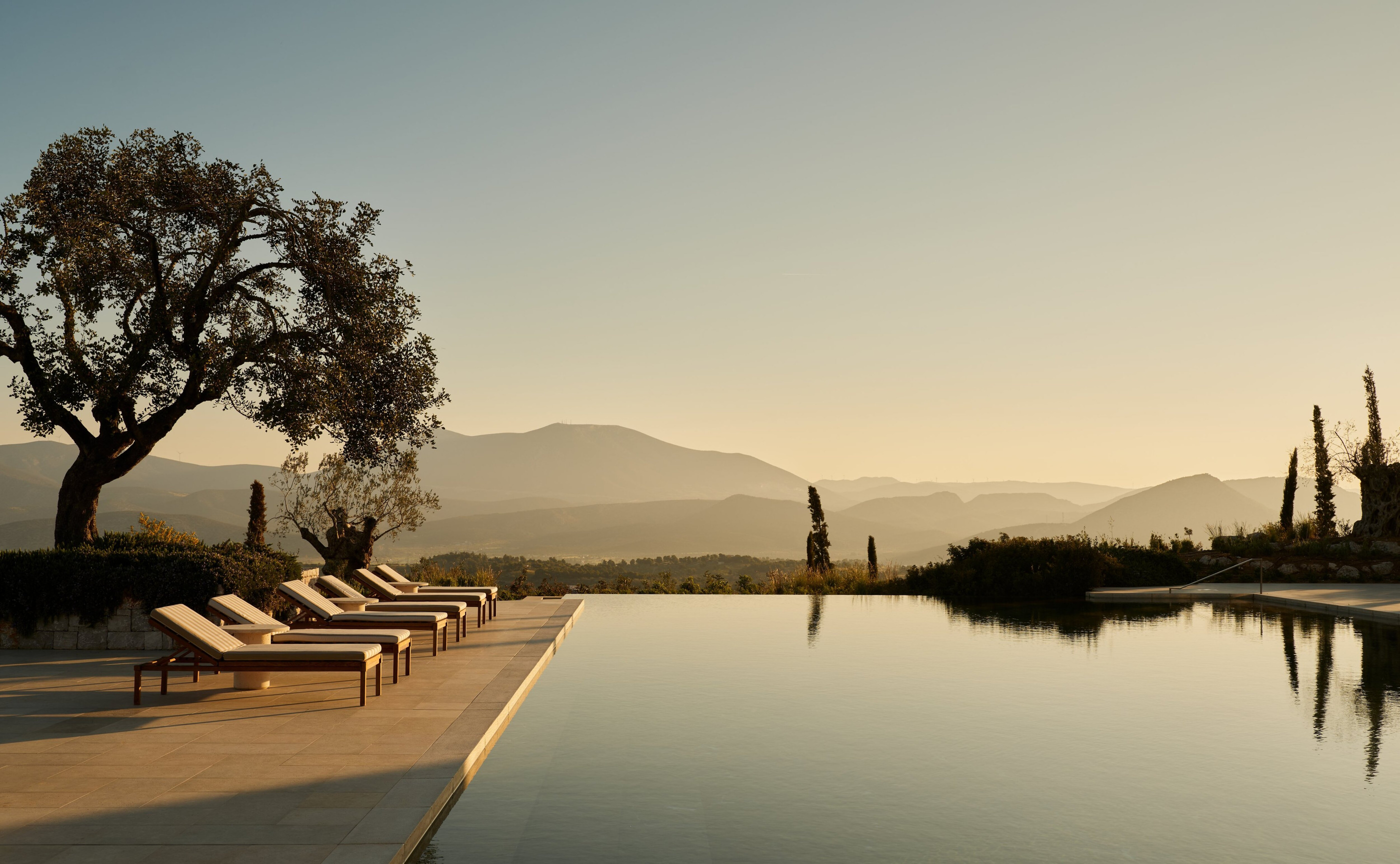 The main resort pool at dawn in official Amanzoe photography