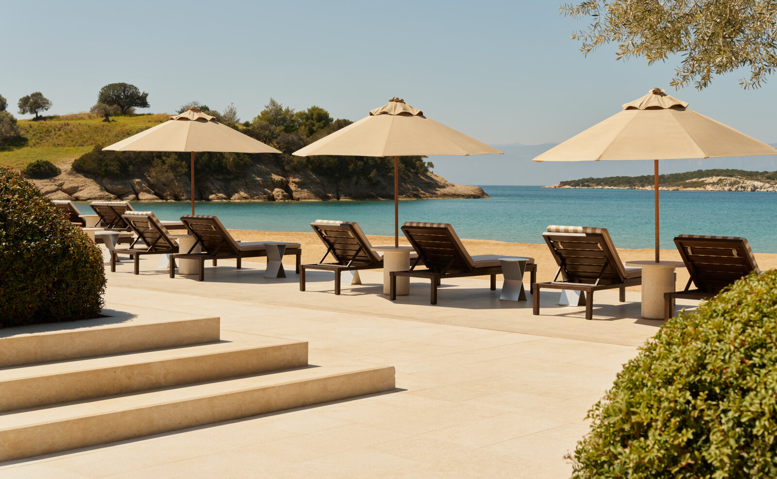 Beach Club loungers arranged beside the water