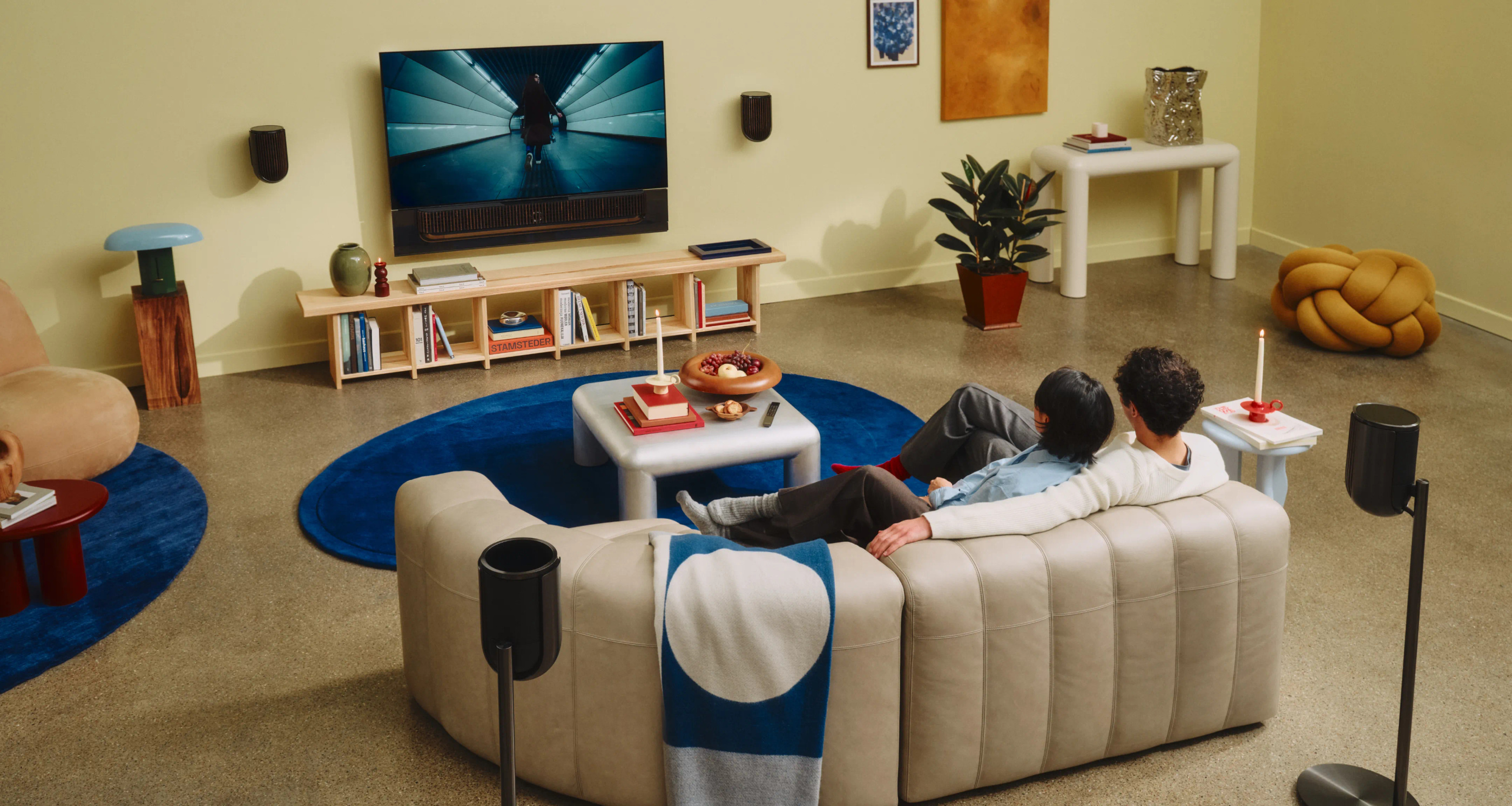 A wider official room photograph showing seating, screen and companion speakers