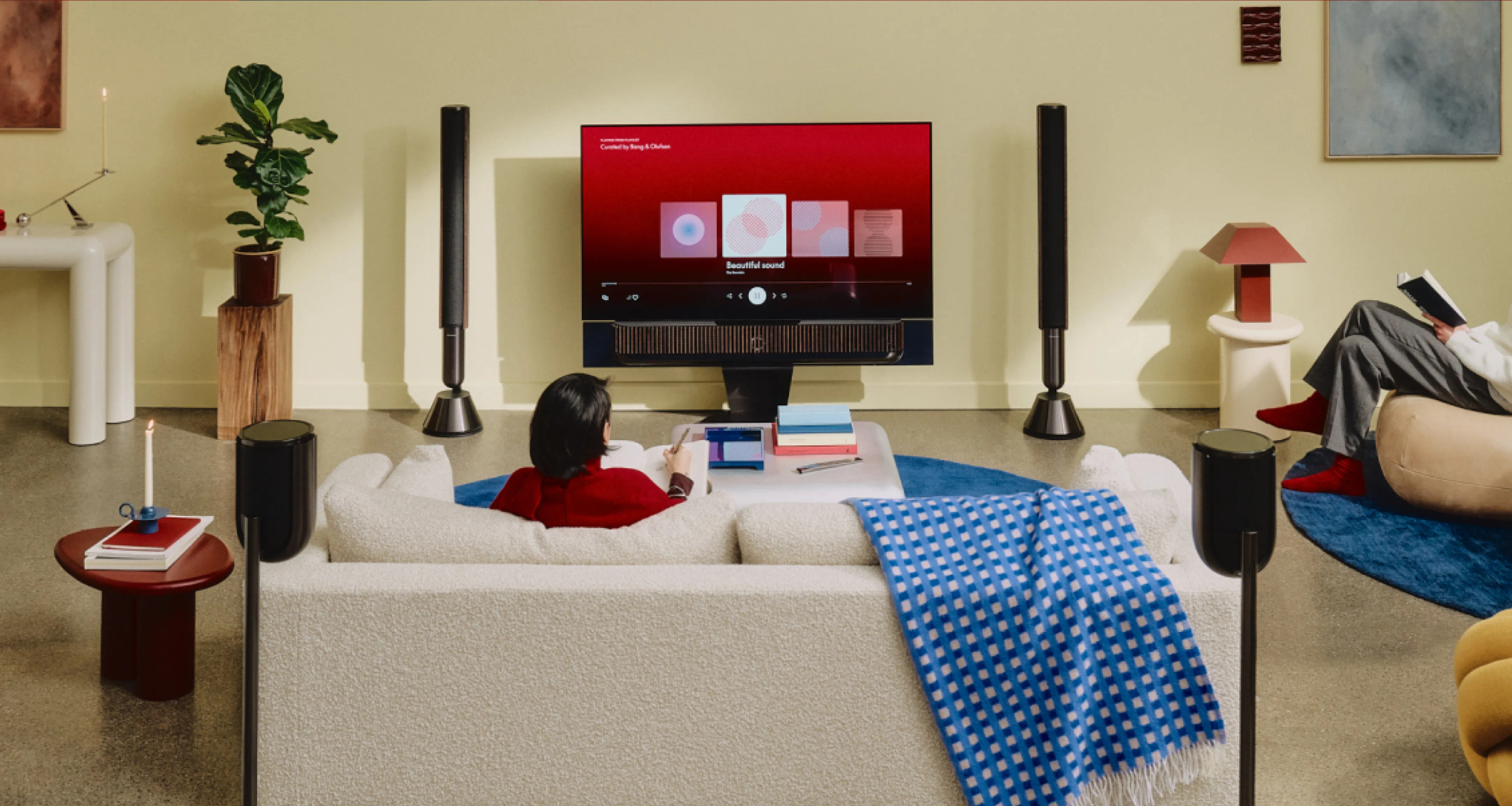 Official room photograph relating the screen and soundbar to a sofa