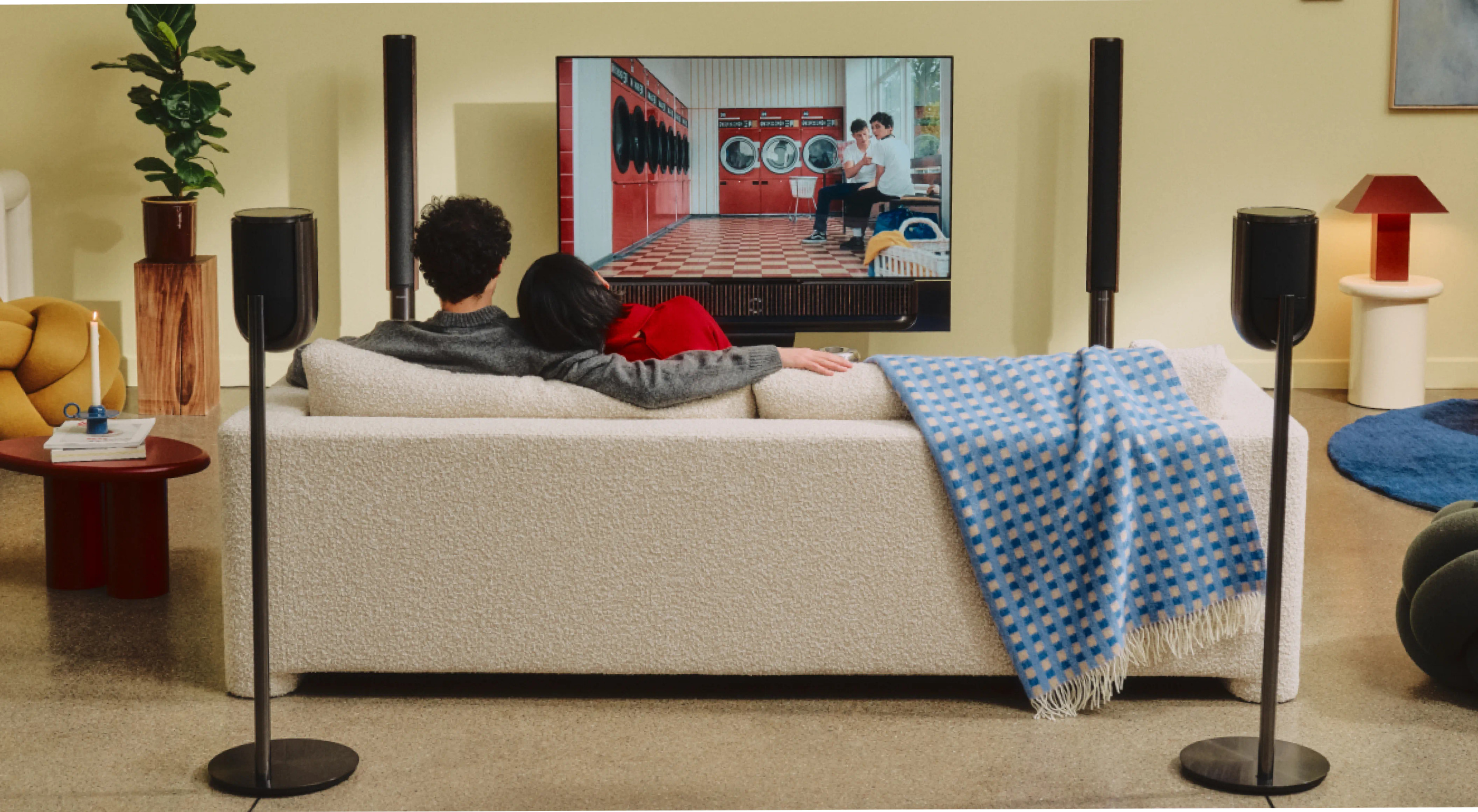 Another official room view of the screen, soundbar and companion speaker layout
