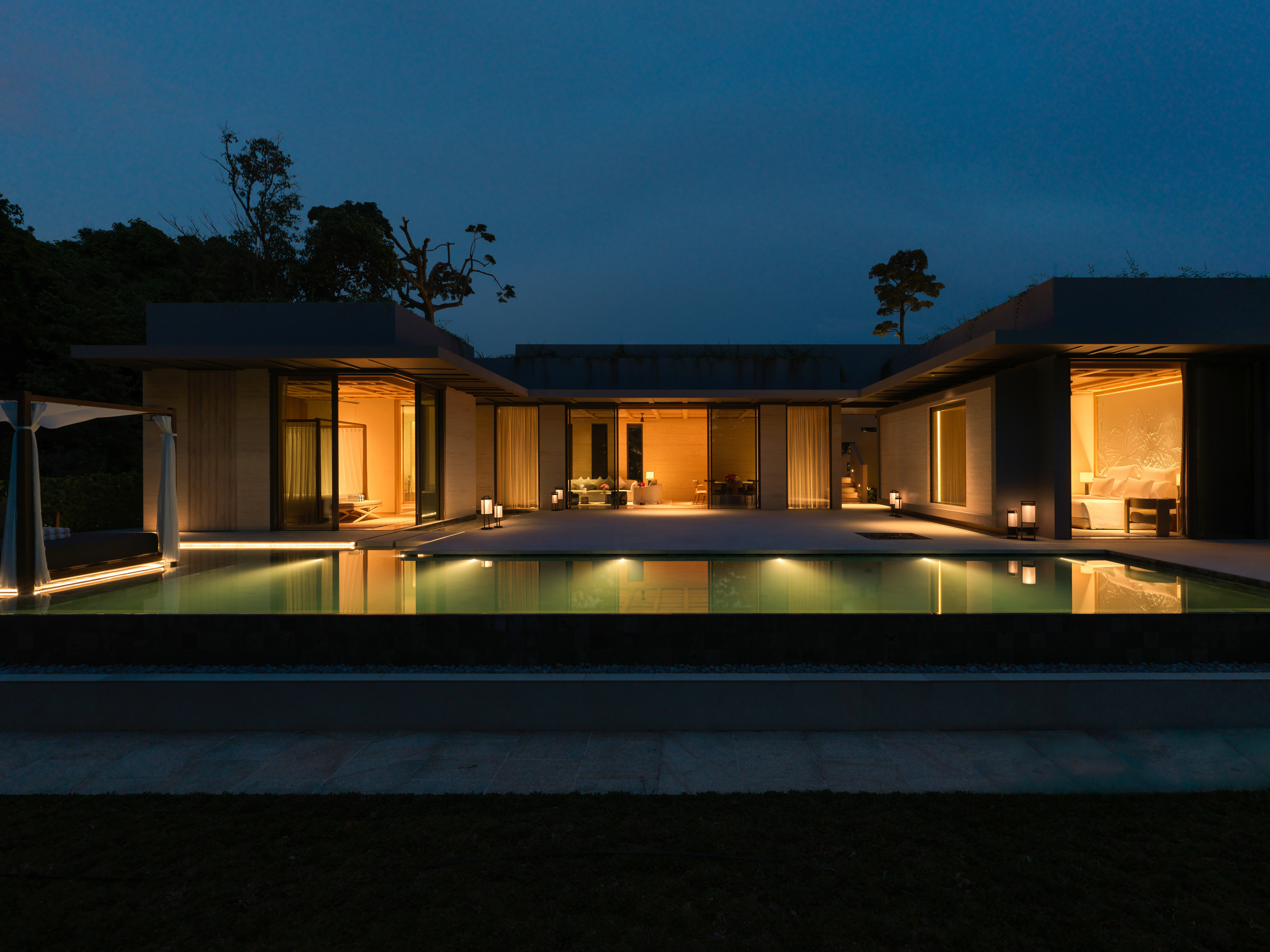 Illuminated villa rooms and pool at dusk in the official resort photograph