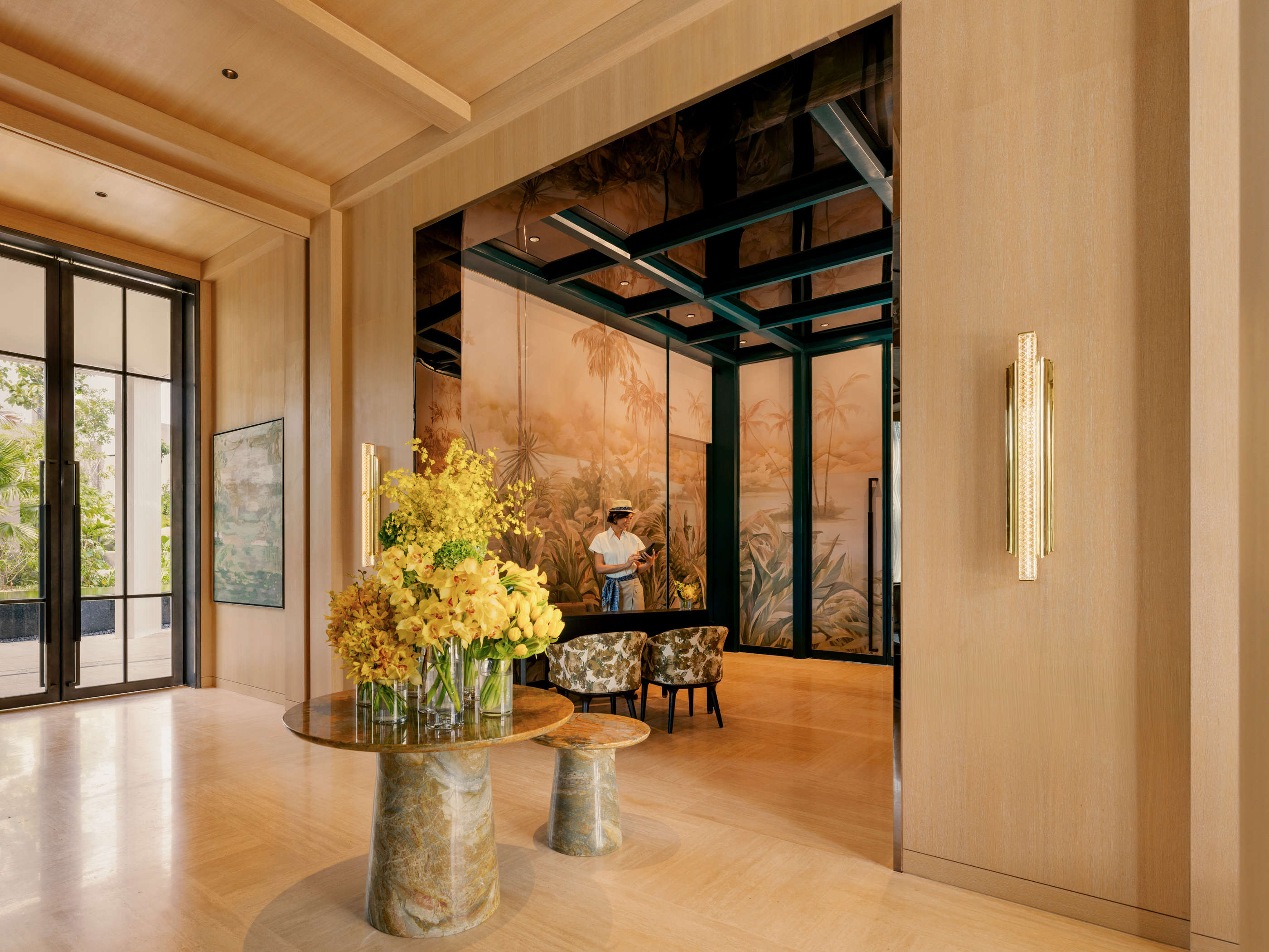 An interior threshold with timber surfaces and flowers in official Raffles Sentosa imagery