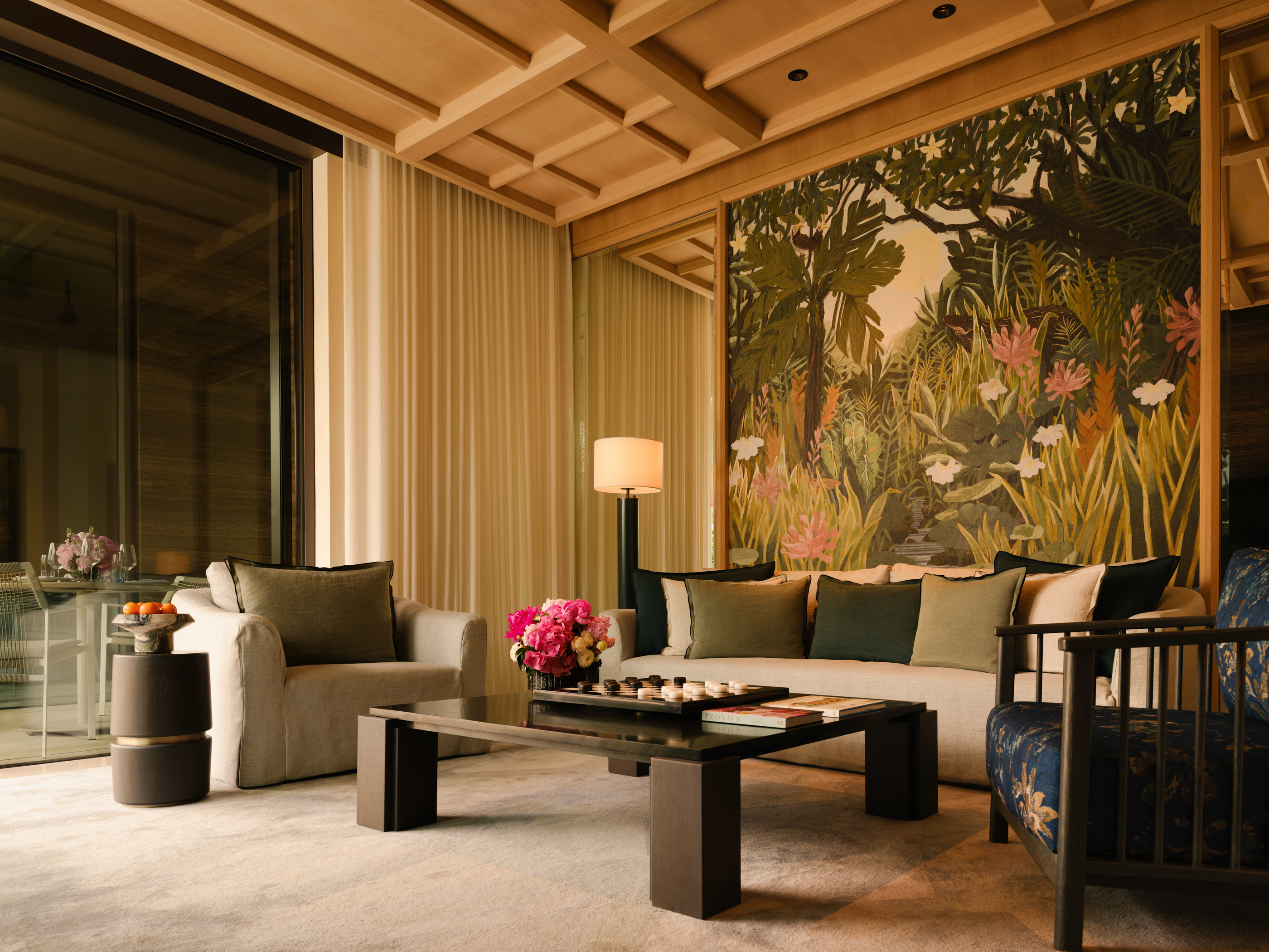 A published villa living room with timber ceiling and a patterned wall panel