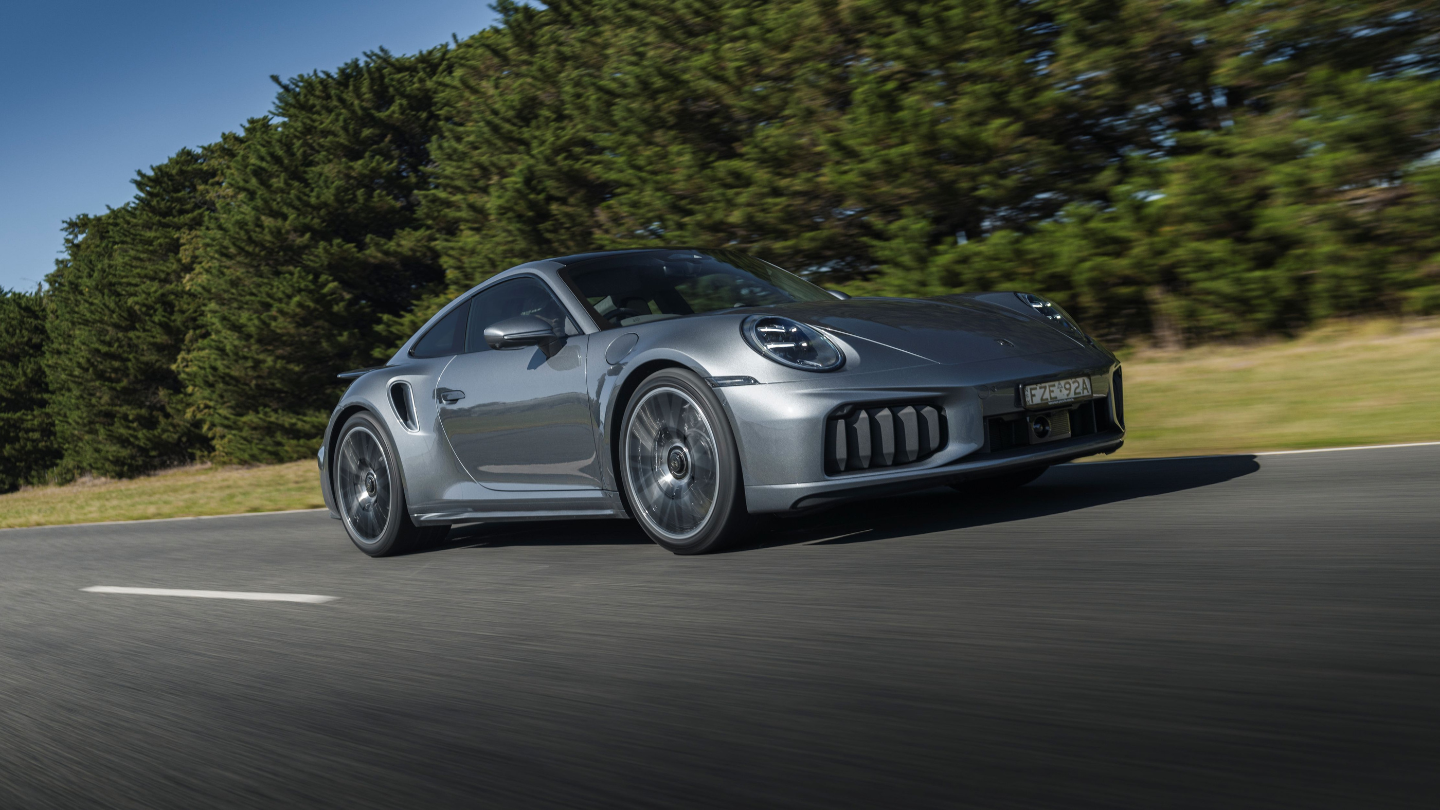 Current 911 Turbo S family in the official grey driving photograph
