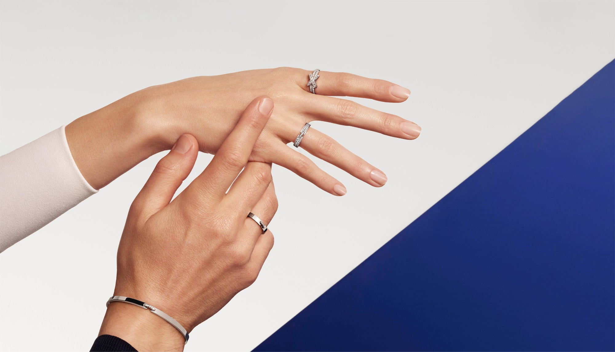 Chaumet Liens jewellery worn at the hands and wrists against a geometric blue background