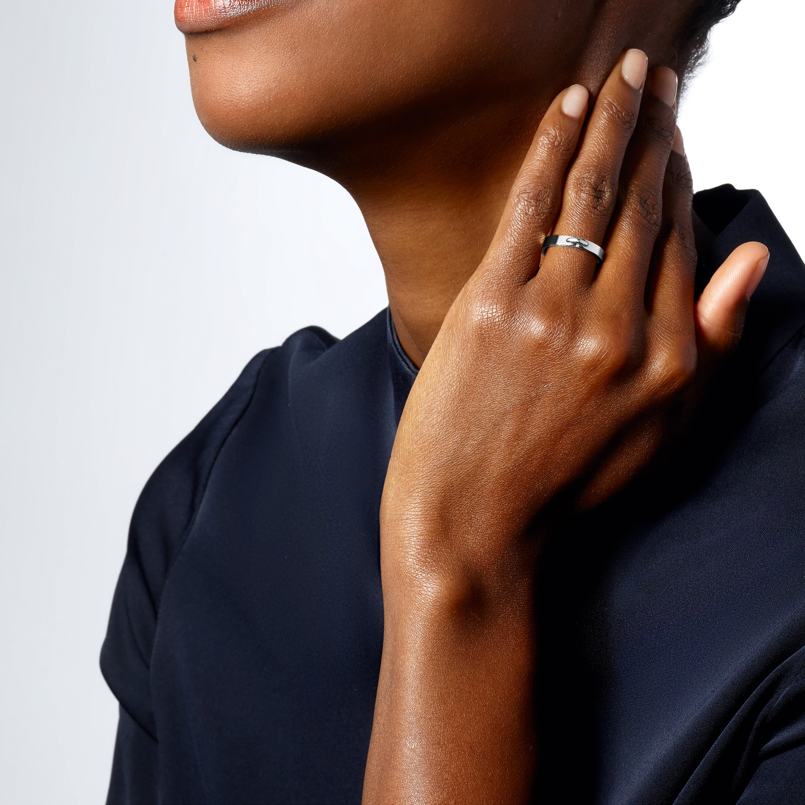 A broad Liens ring worn against dark tailoring