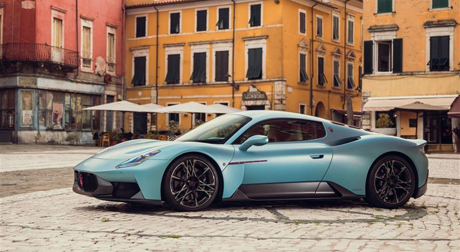 MCPURA coupé in official imagery, with its AI Aqua Rainbow body against a city setting.