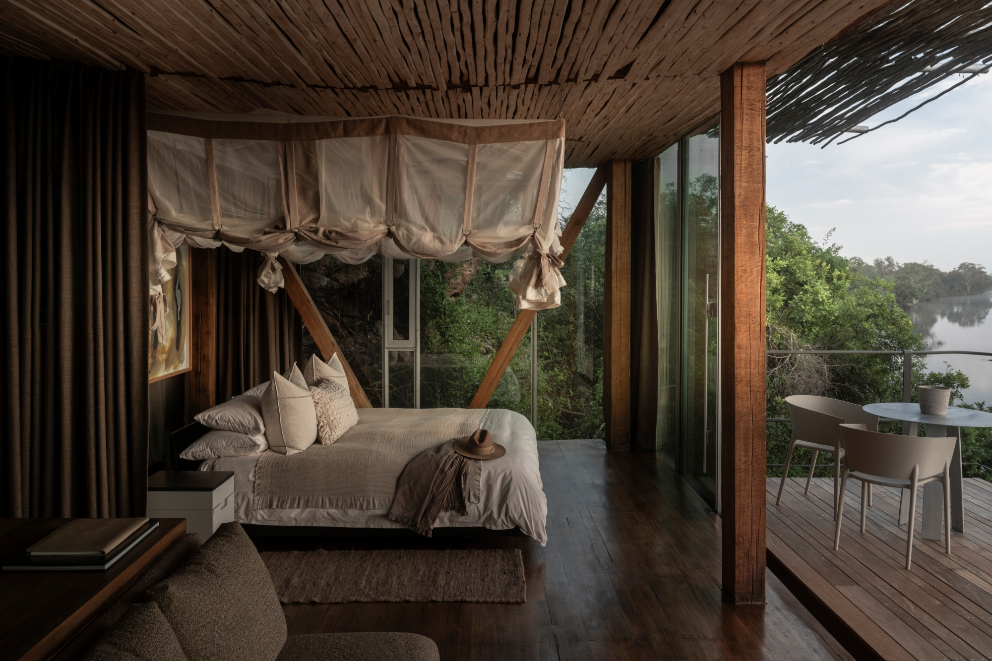 A Lebombo suite with its bed, glazed wall and outdoor setting.