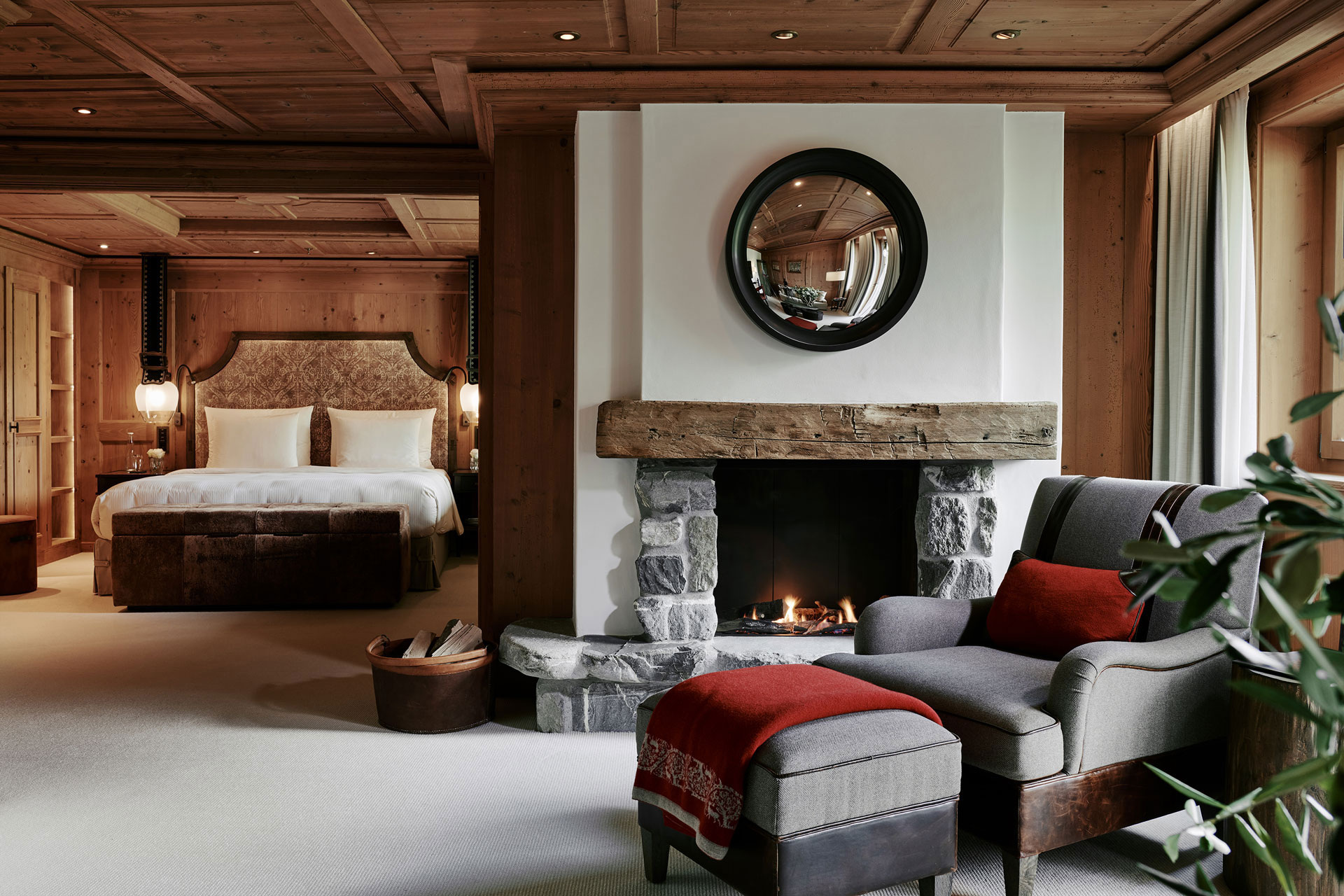 Bedroom and sitting area with a fireplace in The Alpina Gstaad’s accommodation gallery.