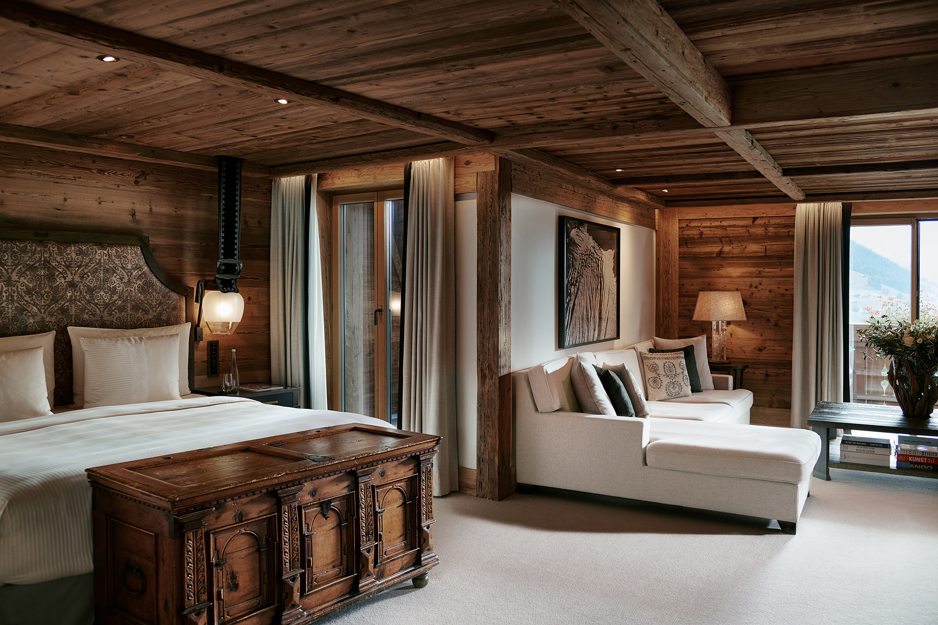 Bedroom framing the mountain landscape through a large window.