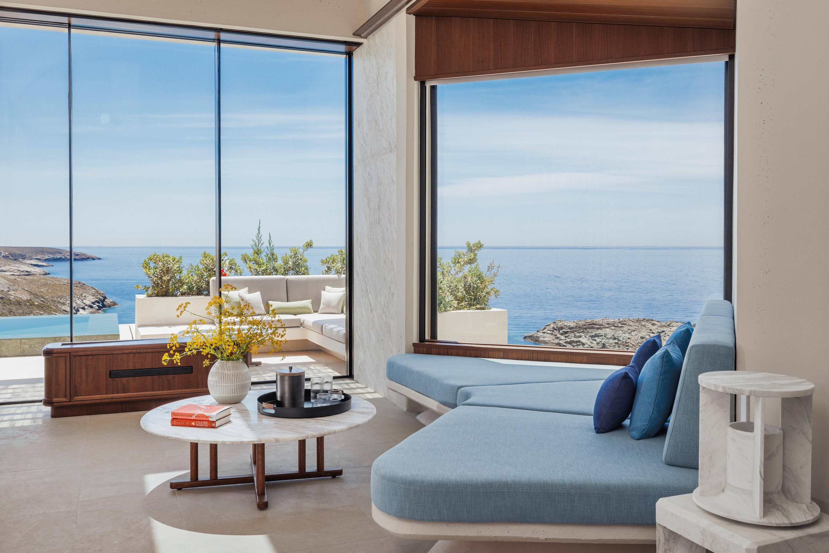A villa sitting area and the sea framed through glazing.