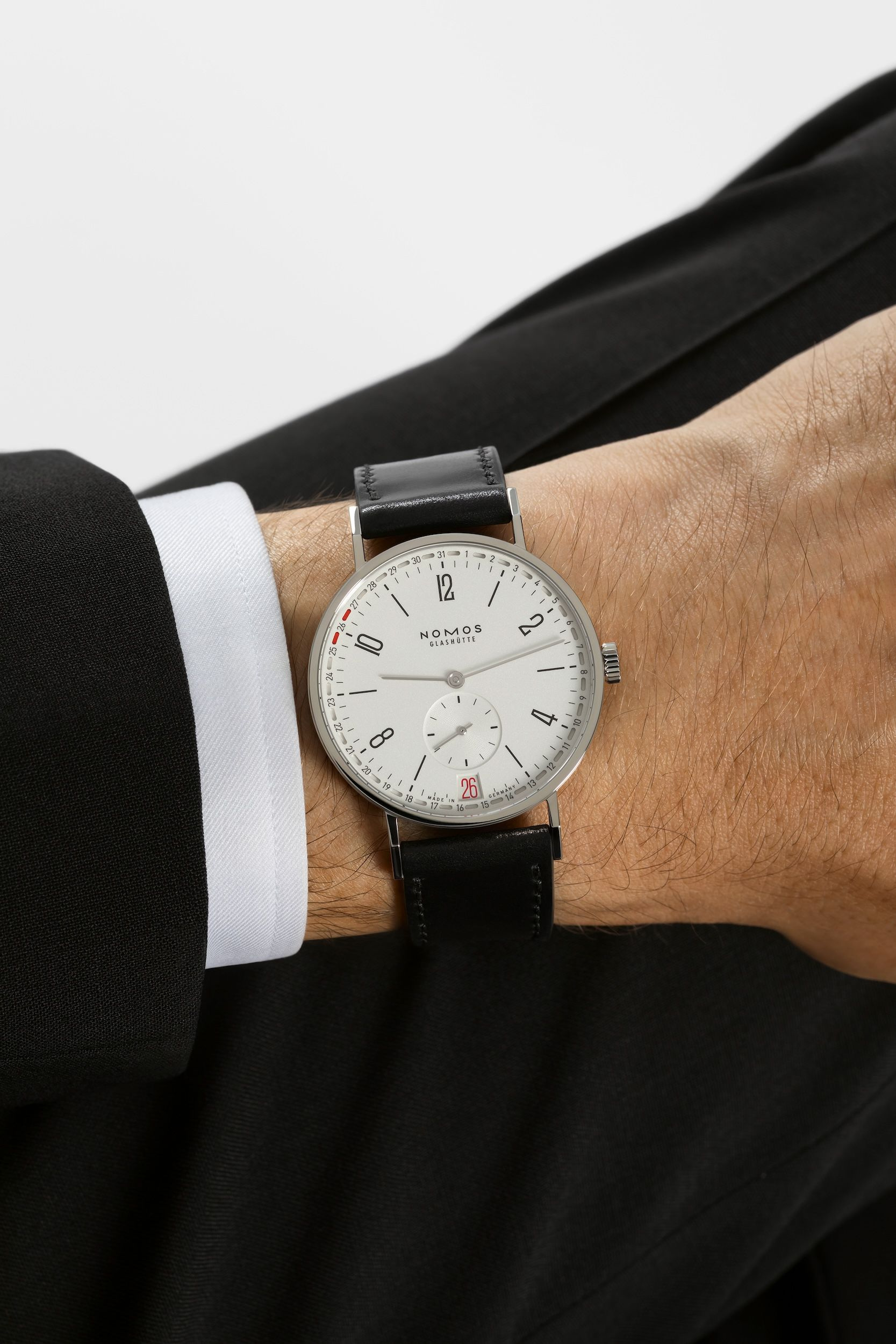Reference 135 on the wrist in NOMOS’ official wearing imagery.
