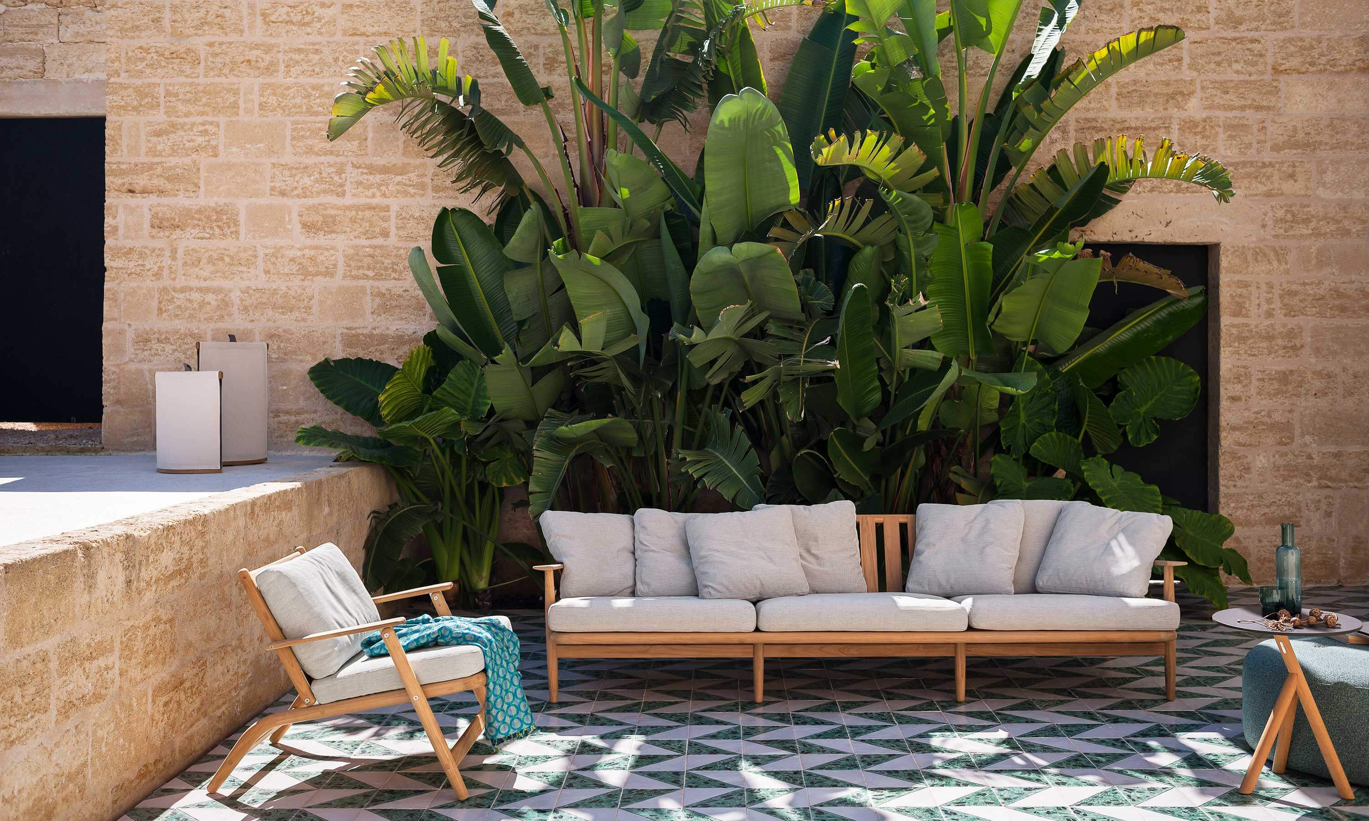 A Levante sofa and armchair establish a shaded conversation setting.