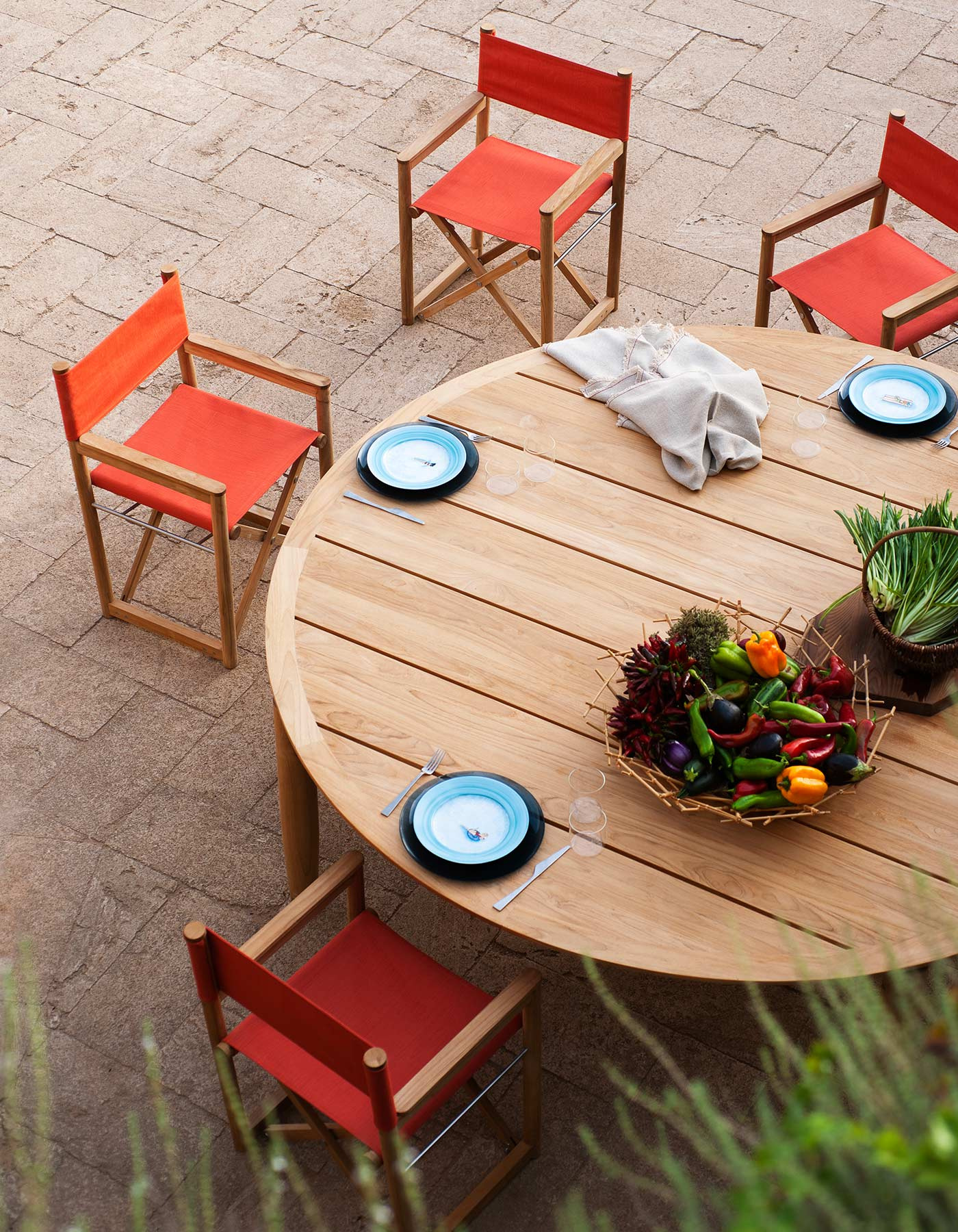 RODA Levante: A Terrace in Three Different Tempos: A round dining setting with red upholstered chairs in the Levante gallery. Official illustration; not a private object or commissioned examination.