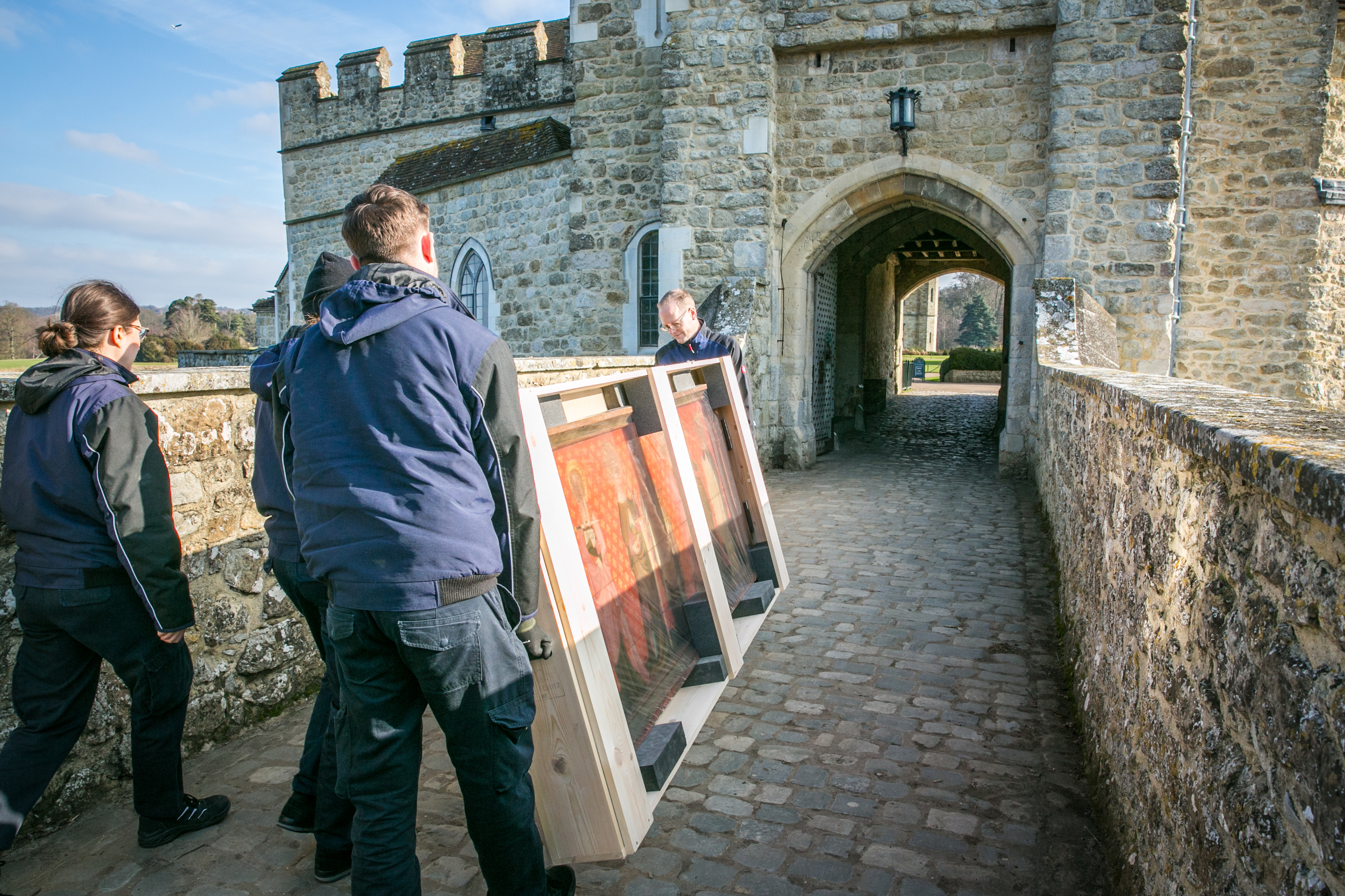 Gander & White published installation view at a historic building, showing a framed work and handling team.