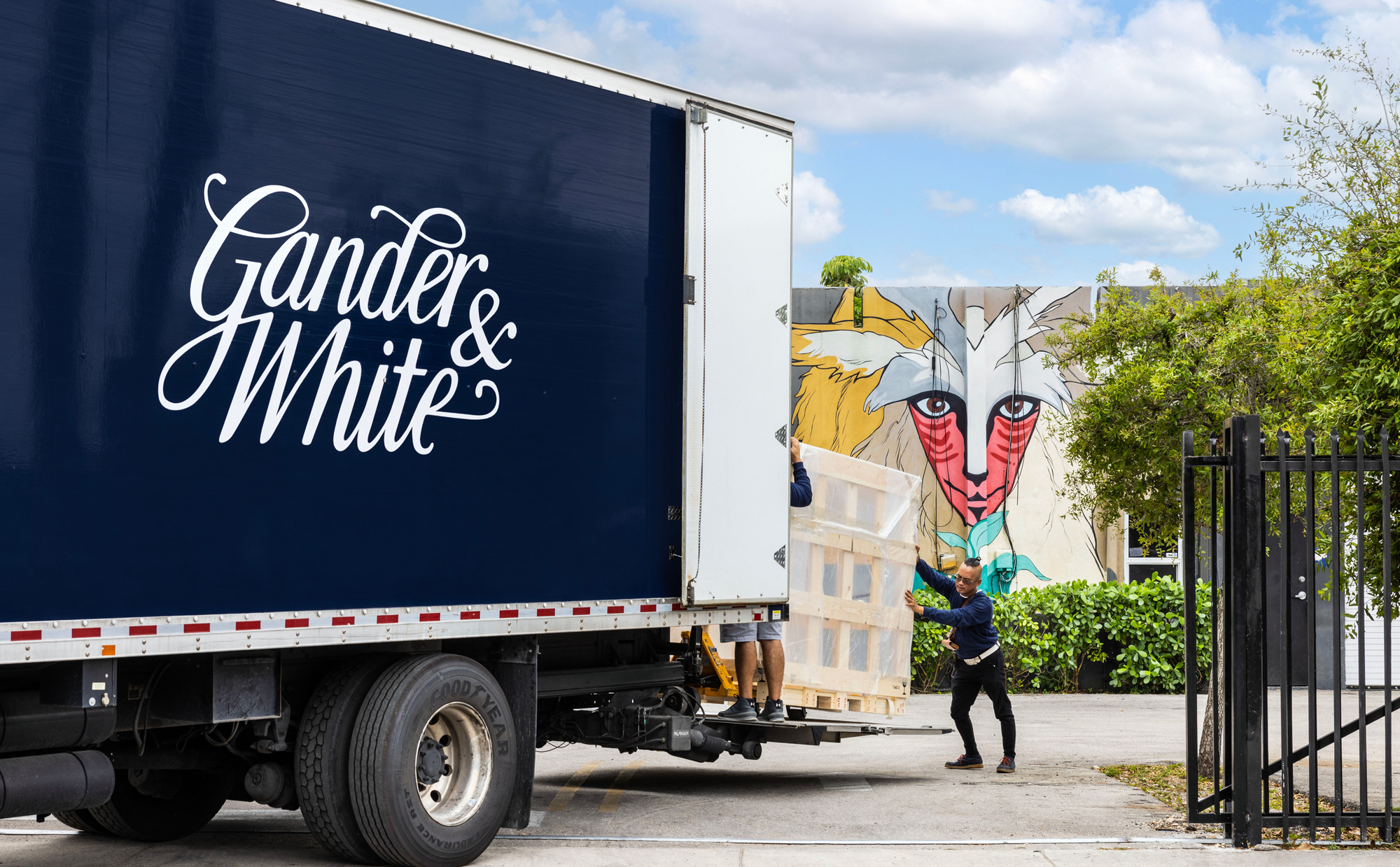 A handling team beside a Gander & White vehicle; official loading illustration.