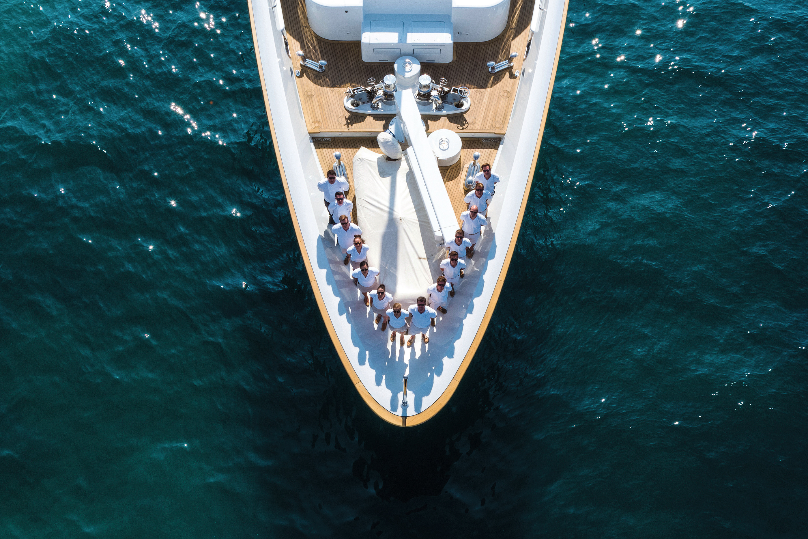 A crew group on a yacht’s foredeck in Burgess’s official management imagery.