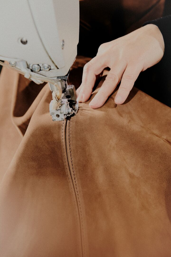 Guiding a seam through a sewing machine in Baxter’s production sequence.