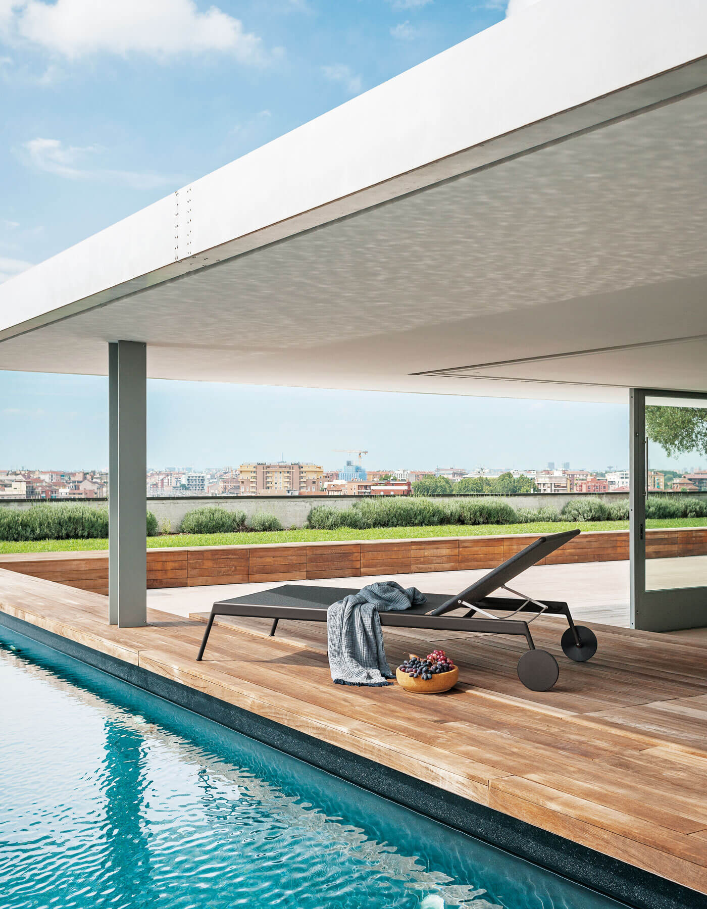 The Piper sunlounger in a covered outdoor setting published by RODA.