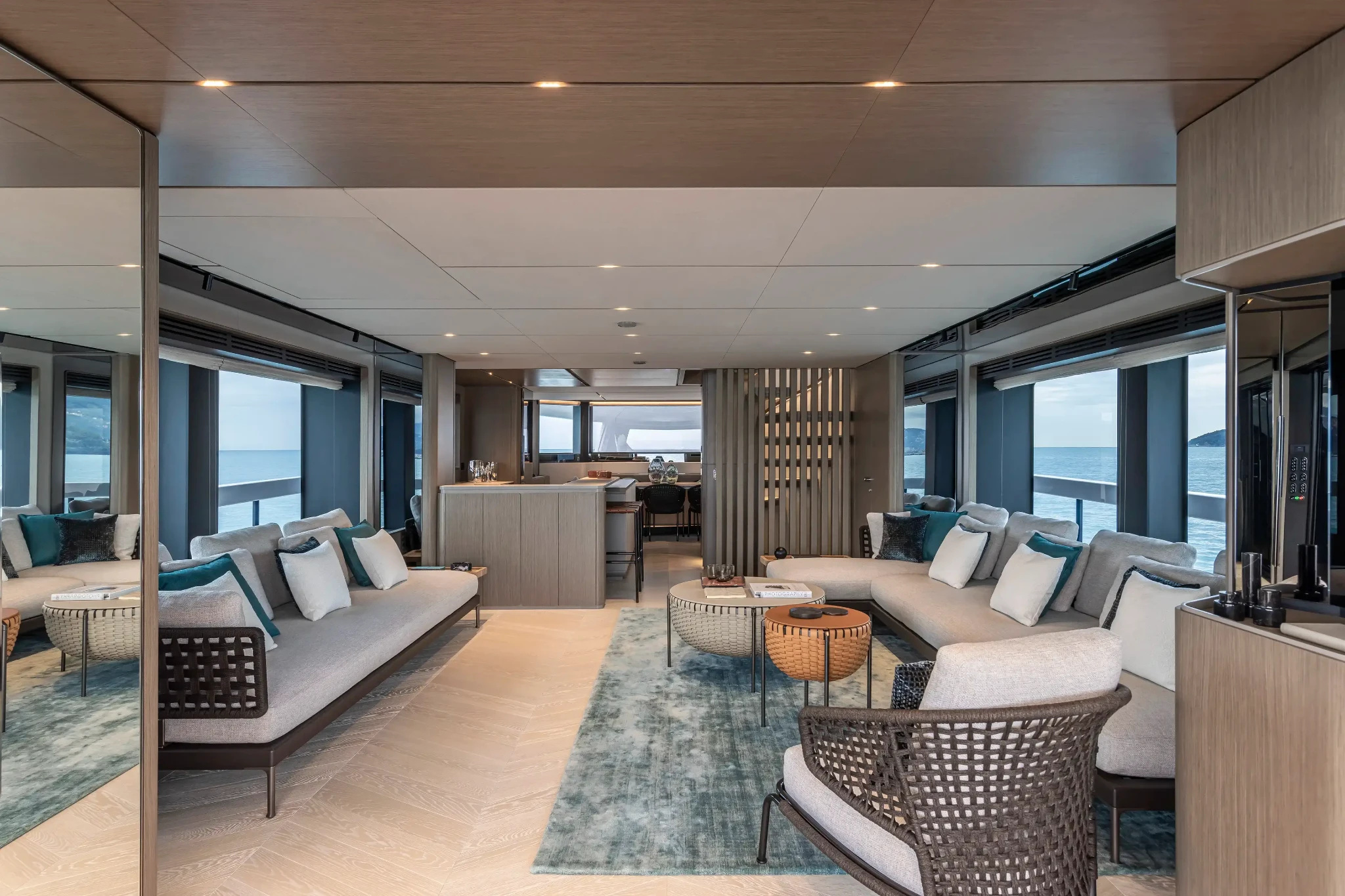 A saloon view in the INFYNITO 90 model gallery, with long windows and pale furnishings.