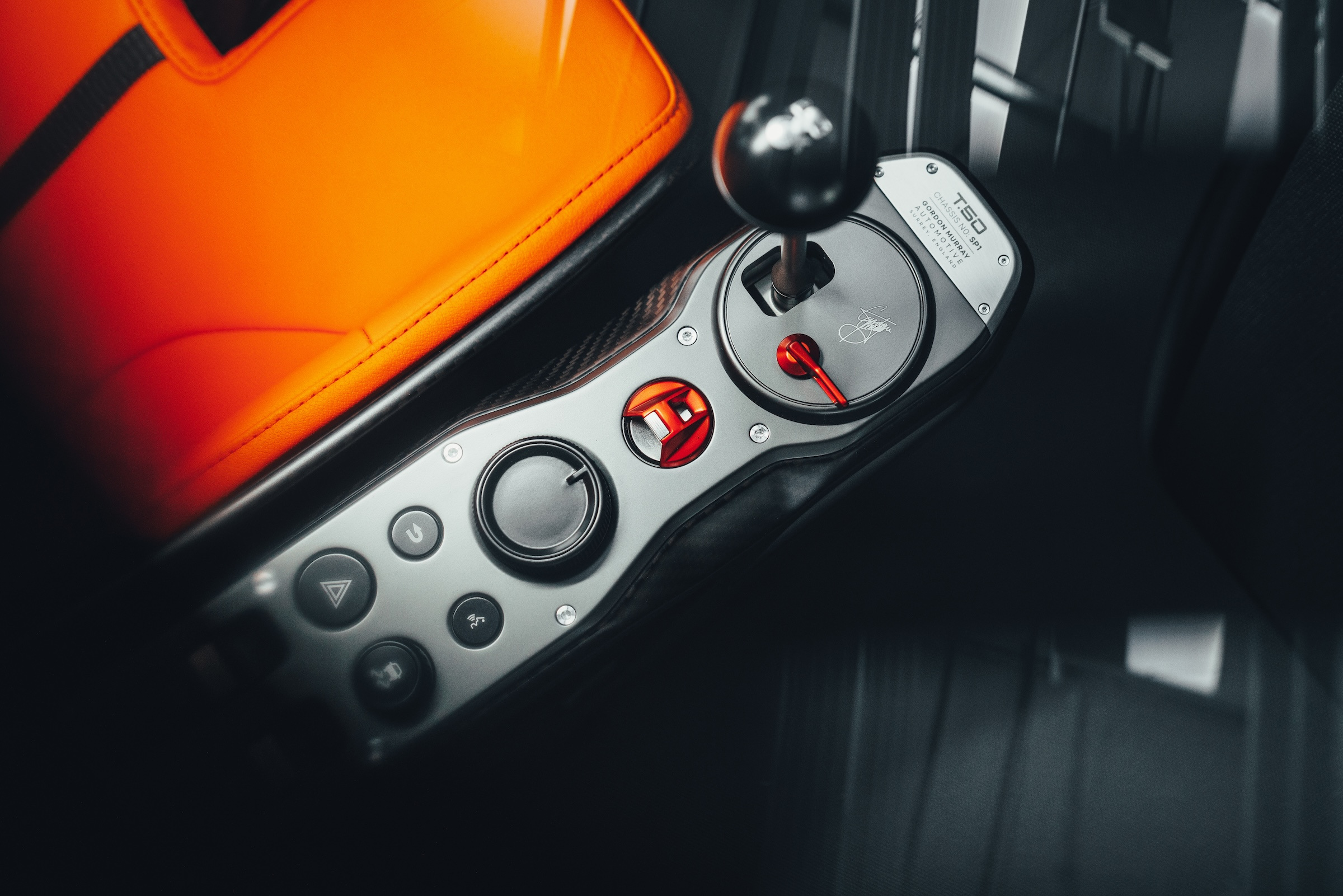 The manual gear lever and exposed supporting arrangement beside the driver.
