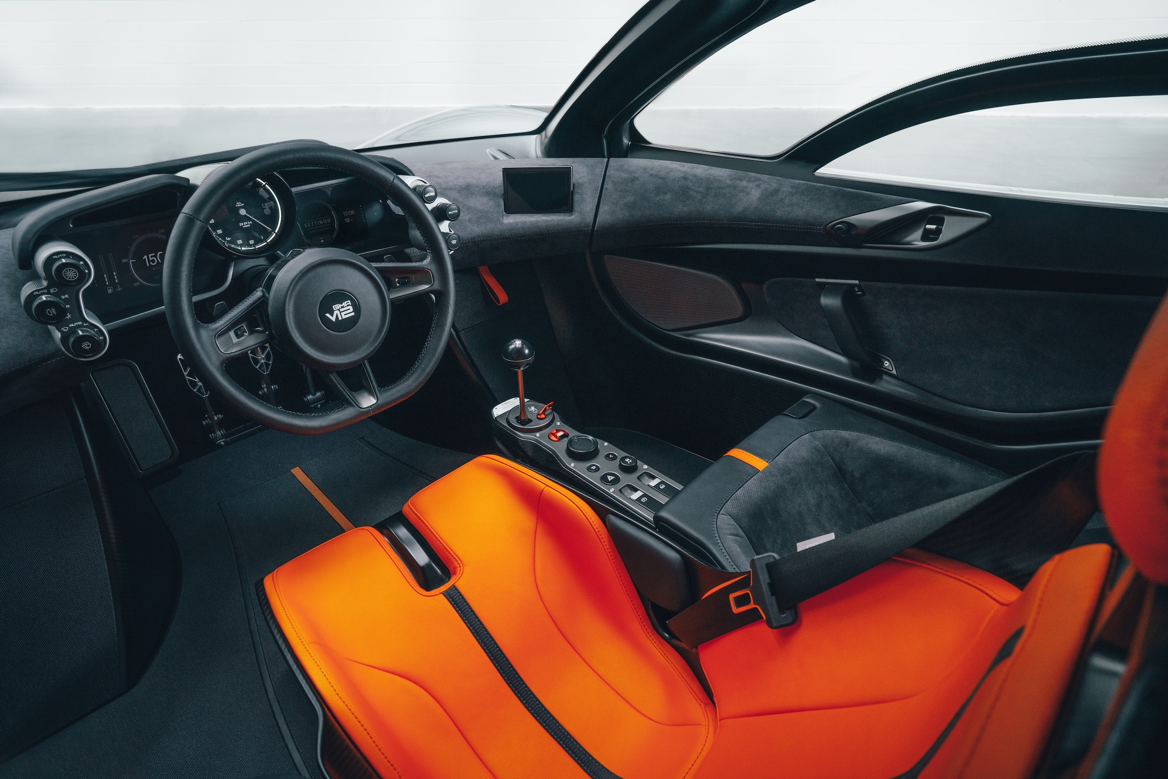 A second cockpit view connects the steering wheel, central seat and gear lever.