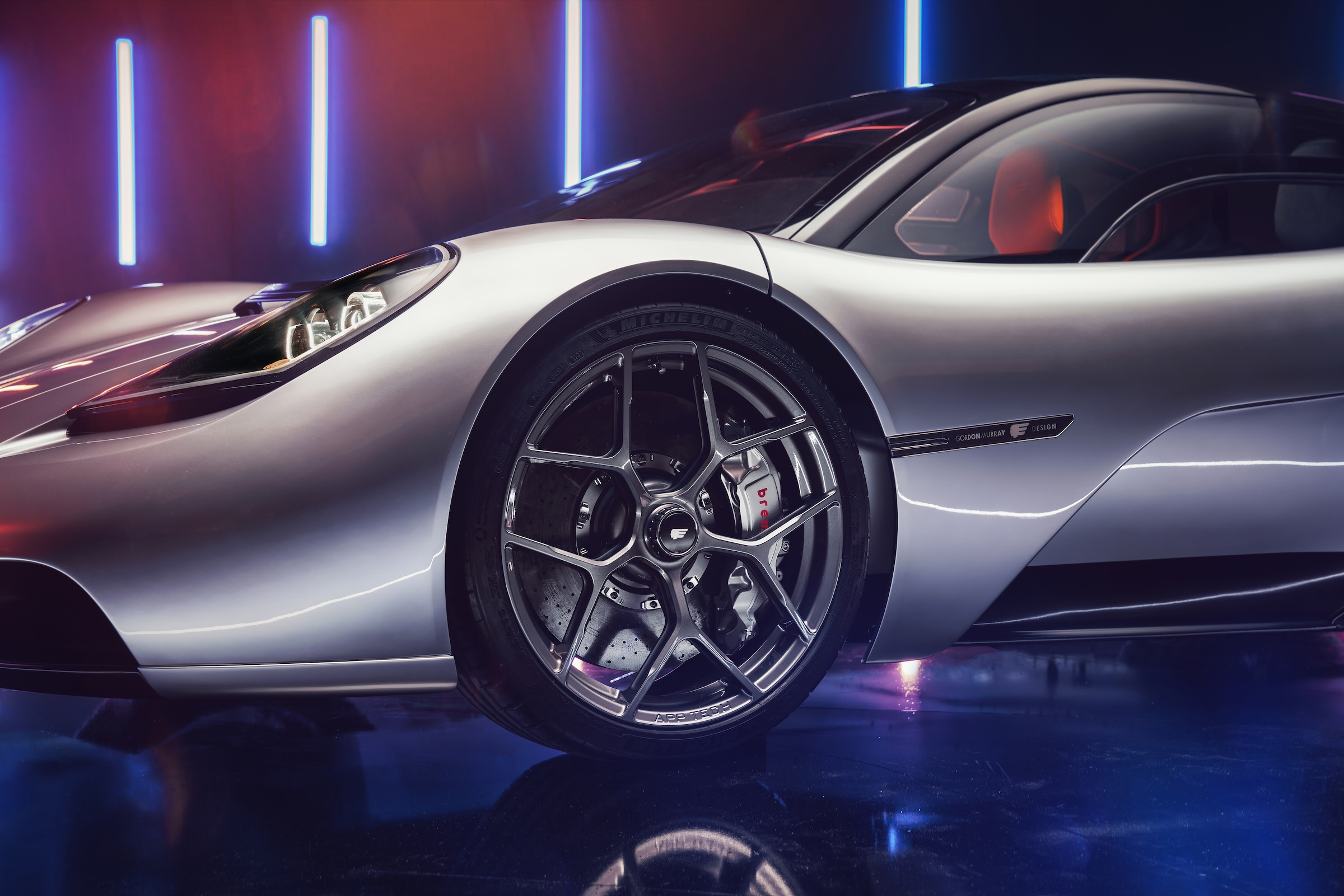 The front wheel and adjoining body surfaces under the studio lighting.