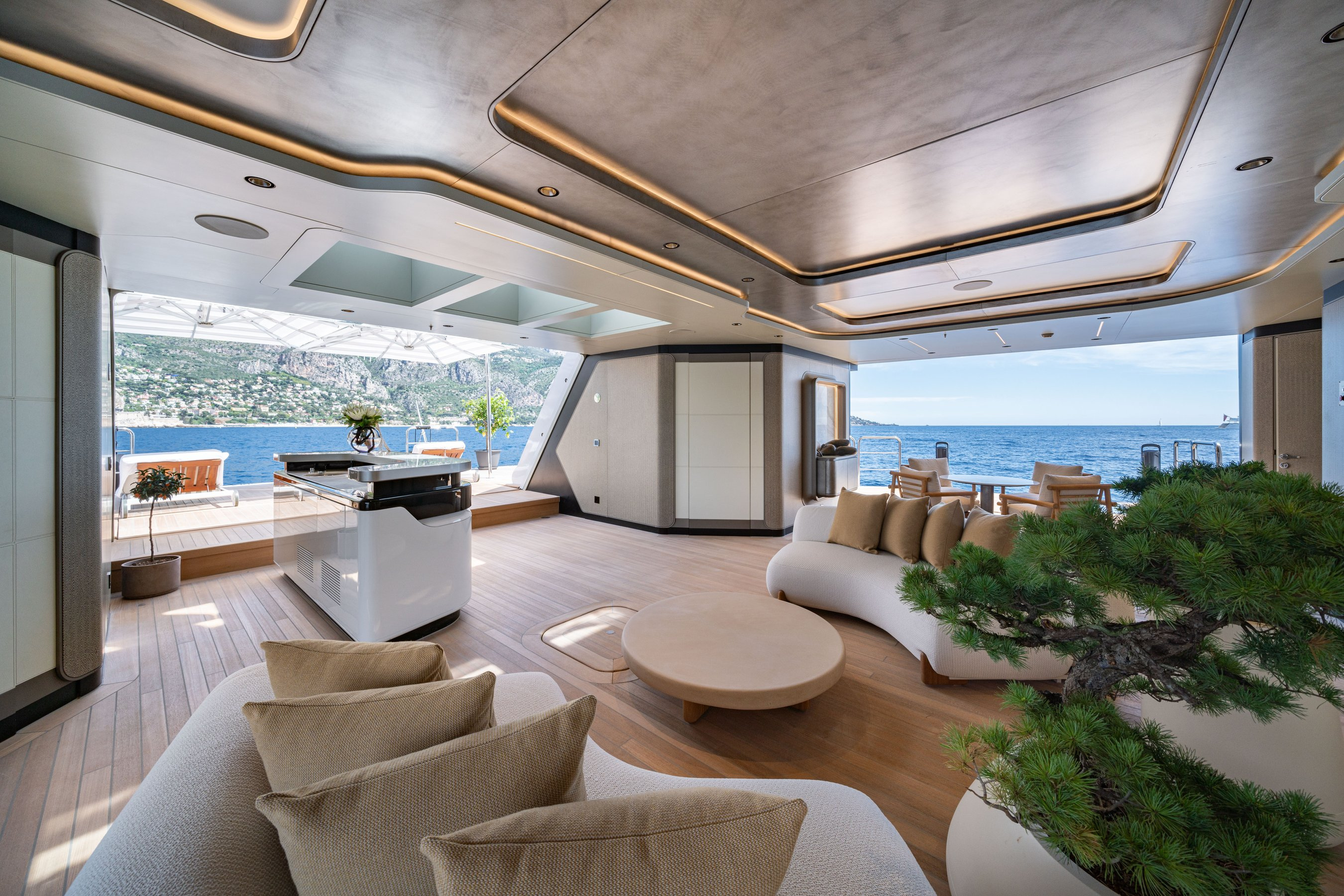 MALIA’s beach-club room connects low seating with open views towards the water.