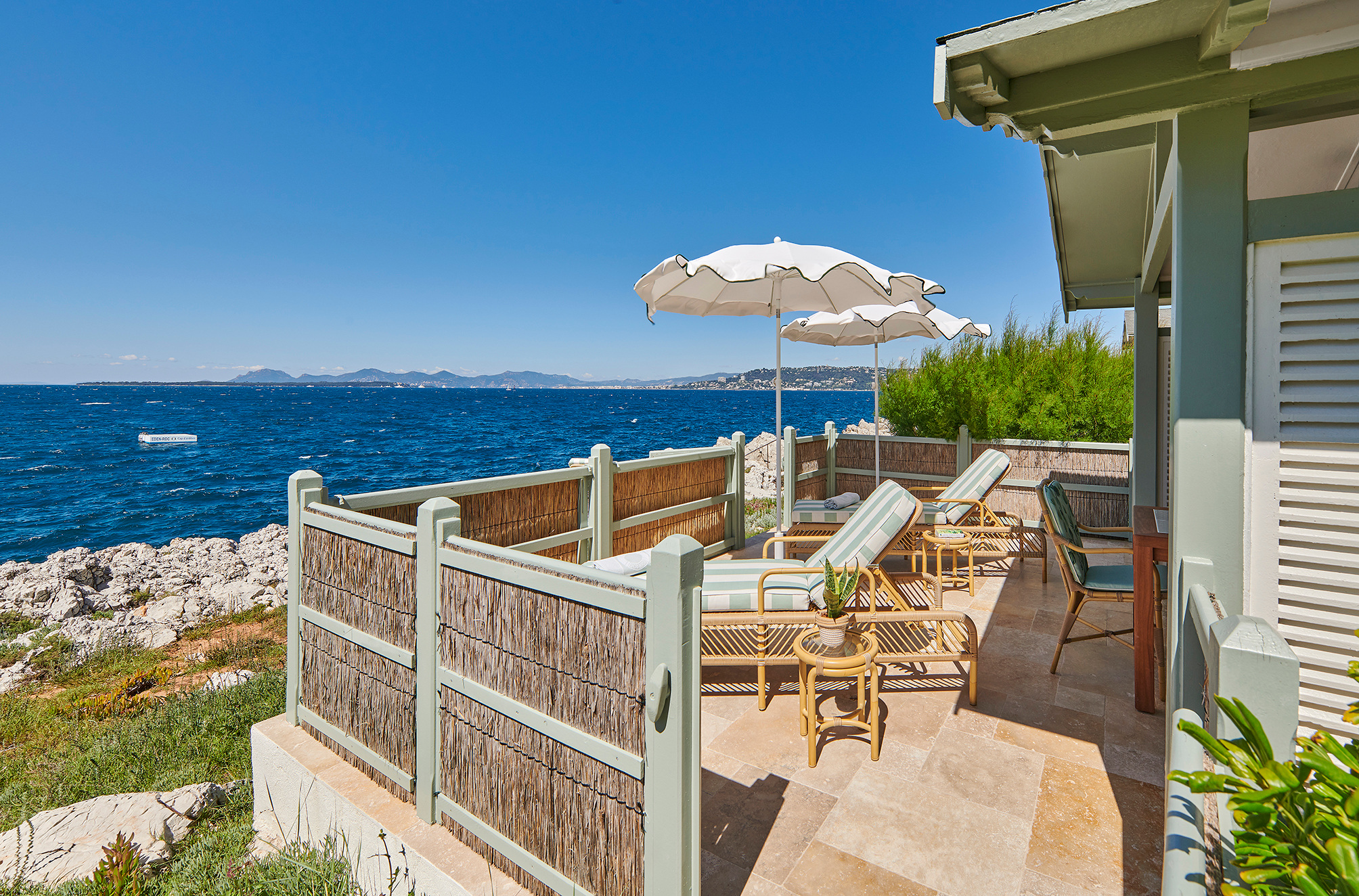 A cabana terrace overlooking the water in the hotel’s current photographic sequence.
