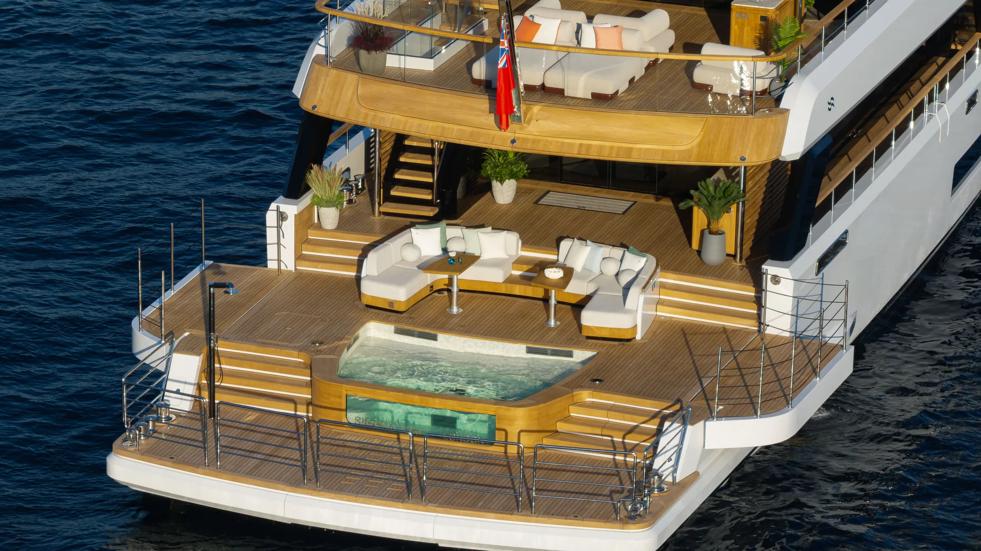 The Sirena 42M stern, showing tiered aft decks, curved seating, pool and swim platform.