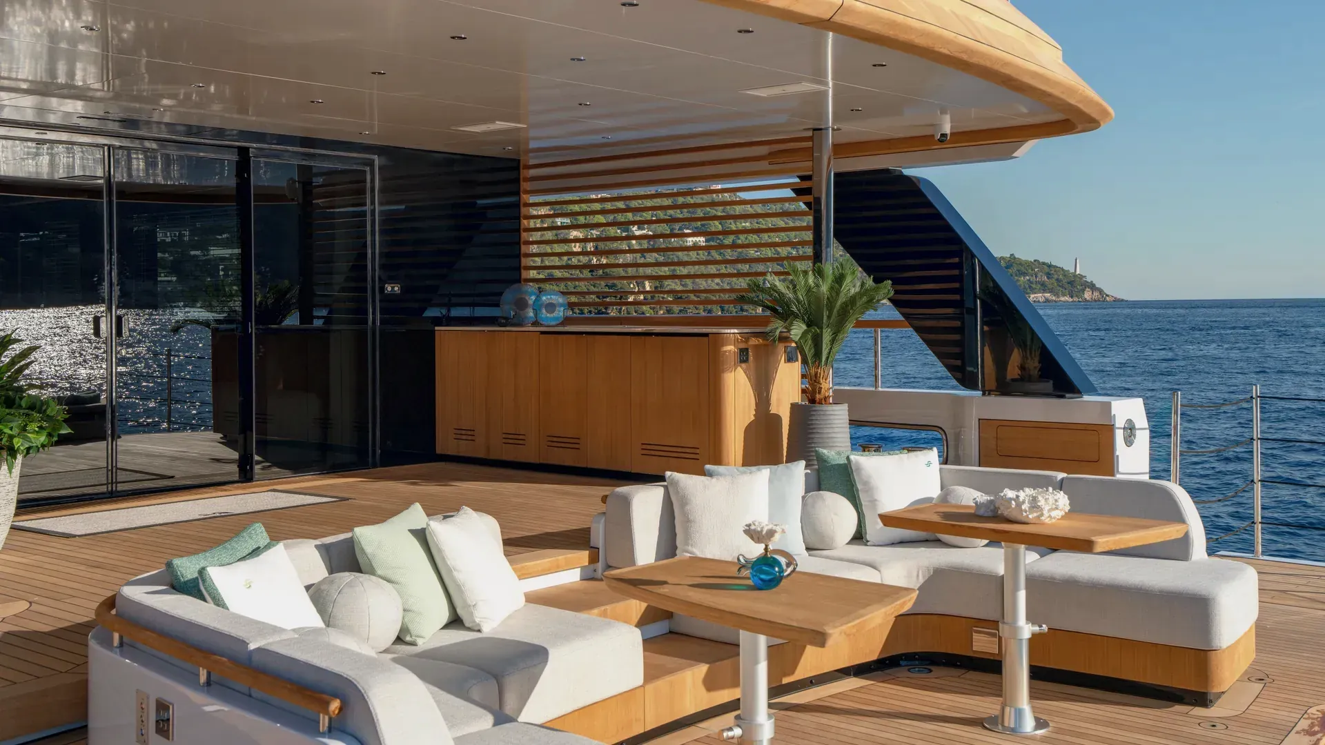 Curved outdoor sofas beside the Sirena 42M aft pool and glazed saloon doors.